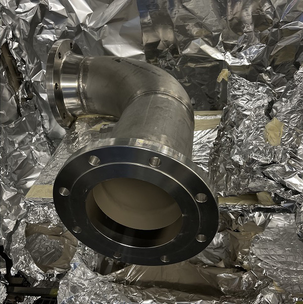 Tube en acier inoxydable revêtu, dans l'enceinte de  la cabine de dépôt par spray. Crédit CEA. 