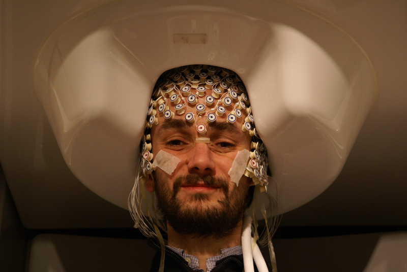 Volontaire installé dans le système MEG et portant un bonnet d'éléctroencéphalographie. L'EEG et le MEG permettent de suivre de 